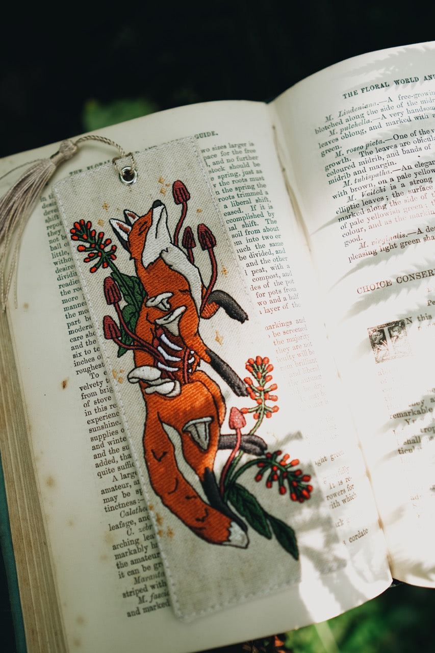 Embroidered fox design on an open book